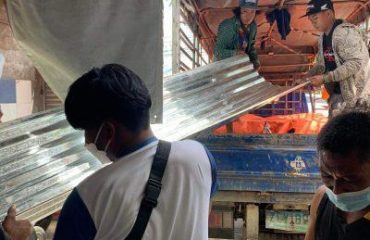 Hombre llevando chapa galvanizada en Filipinas