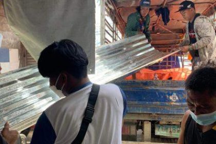 Hombre llevando chapa galvanizada en Filipinas